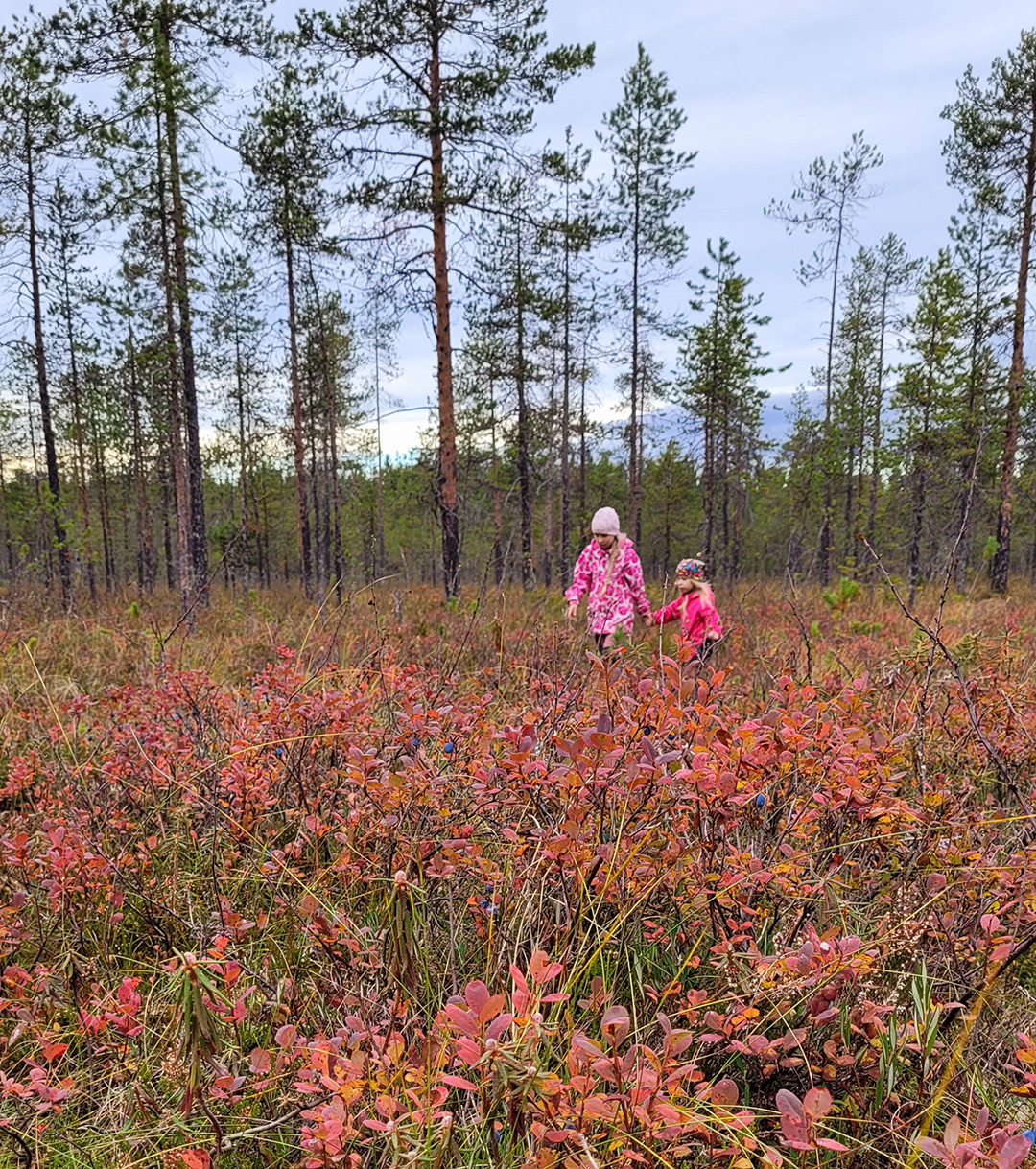 Kuvassa kaksi lasta retkellä kävelemässä maaruskaa hyvin kuvaamassa metsässä.