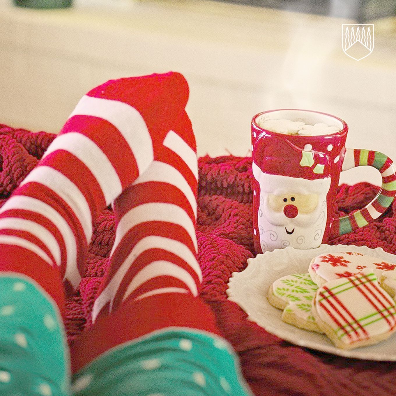 Kuvassa punavalkoiset joulusukat ja punainen jouluinen kaakaomuki.