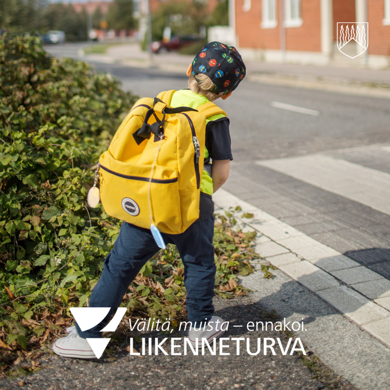 Kuvassa kelta reppuinen lapsi suojatiellä kurkkimassa.