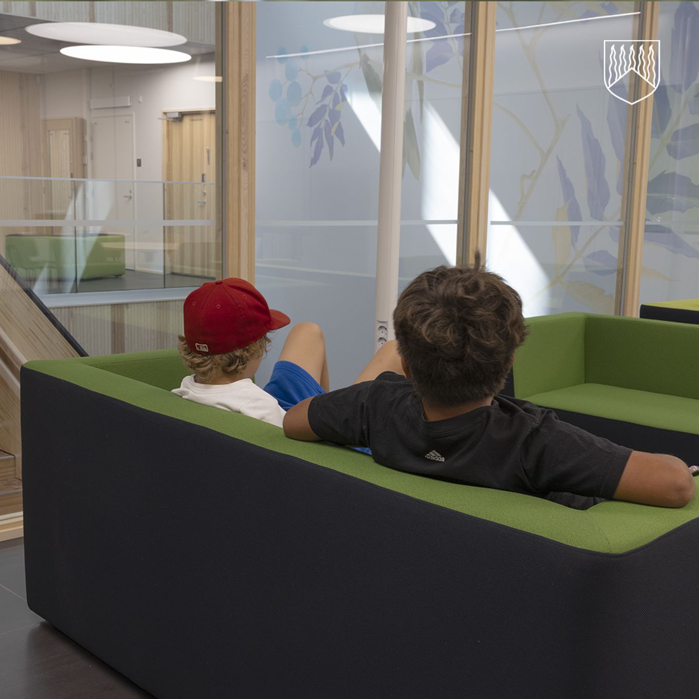 Kaksi poikaa istumassa uuden koulun sohvalla.