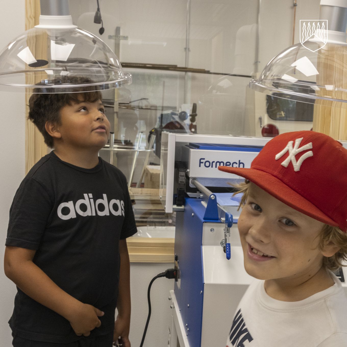 Kaksi lasta uuden monitoimitalon modernissa kovan käsityönluokassa.