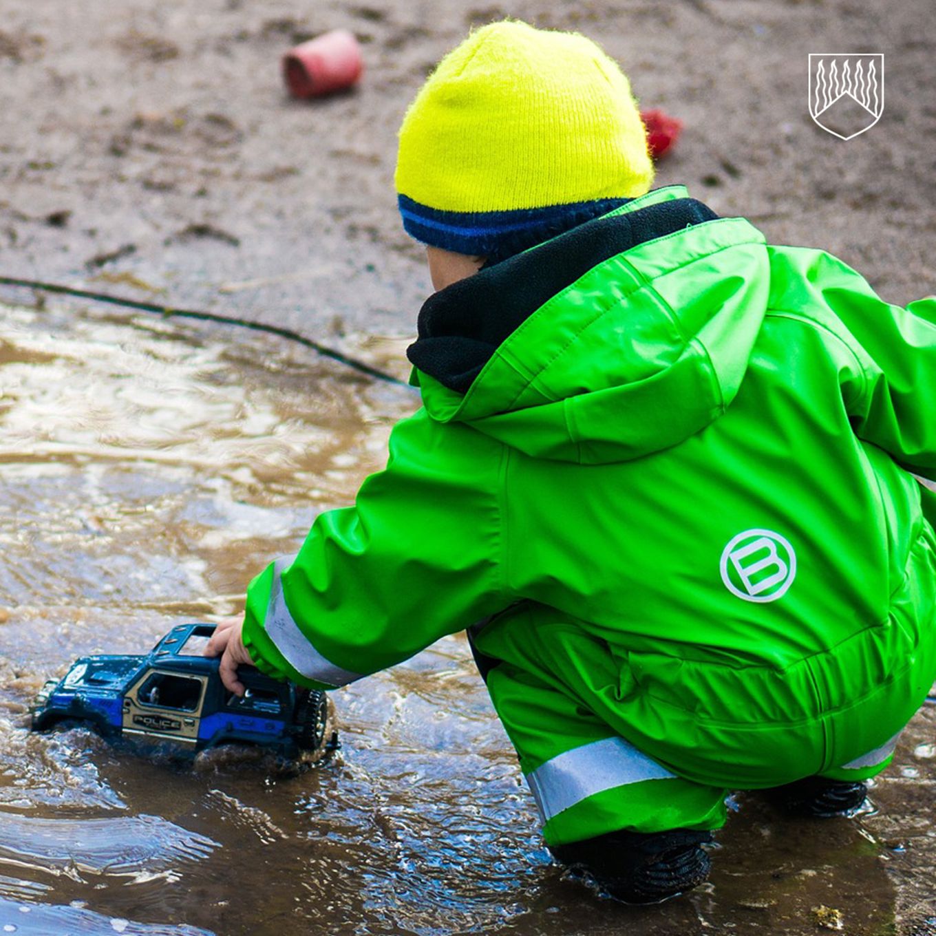 Lapsi läträä kuralätäkössä.