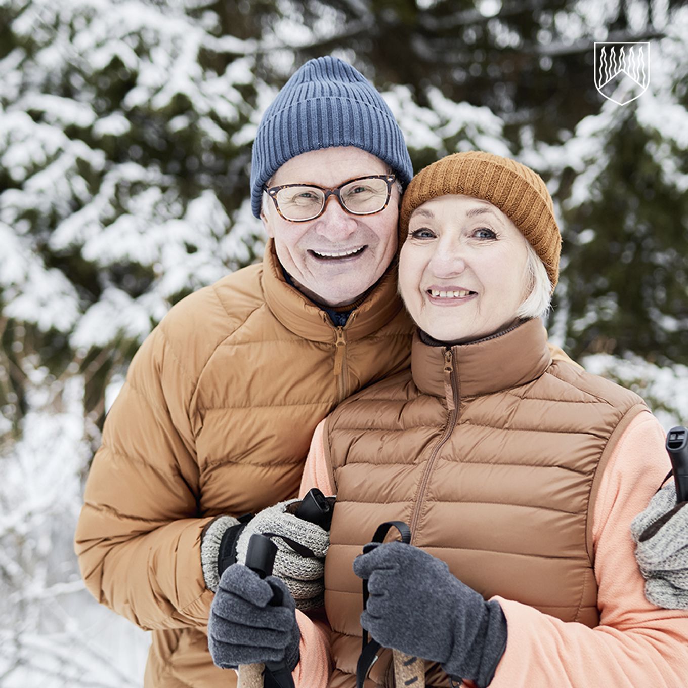 Kuvassa kaksi iloista seniori ikäistä henkilöä ulkoilemassa, sauvakävelemässä.